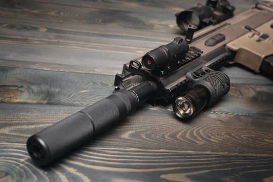 Réplique airsoft équipée d'un silencieux, d'une lampe tactique et d'un point rouge