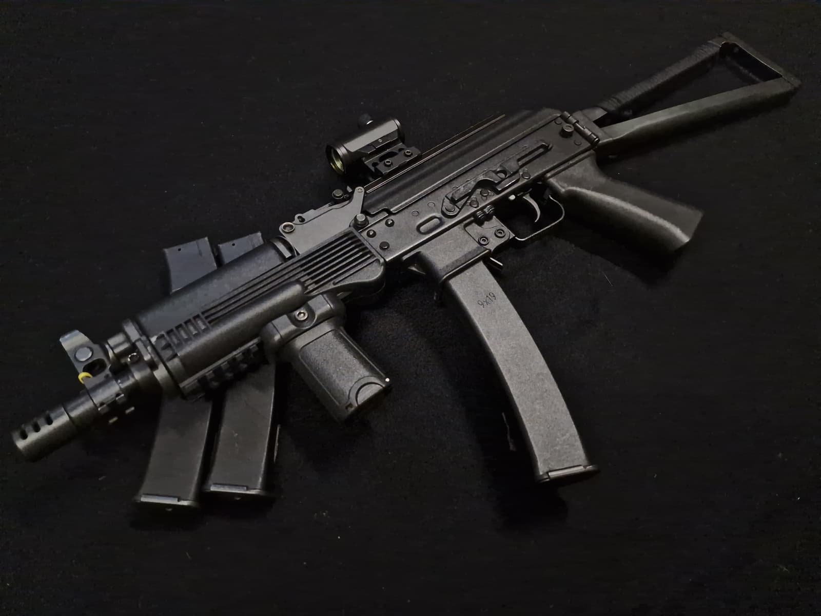 Réplique AEG type mitraillette 9x19 personnalisée avec point rouge et crosse pliante